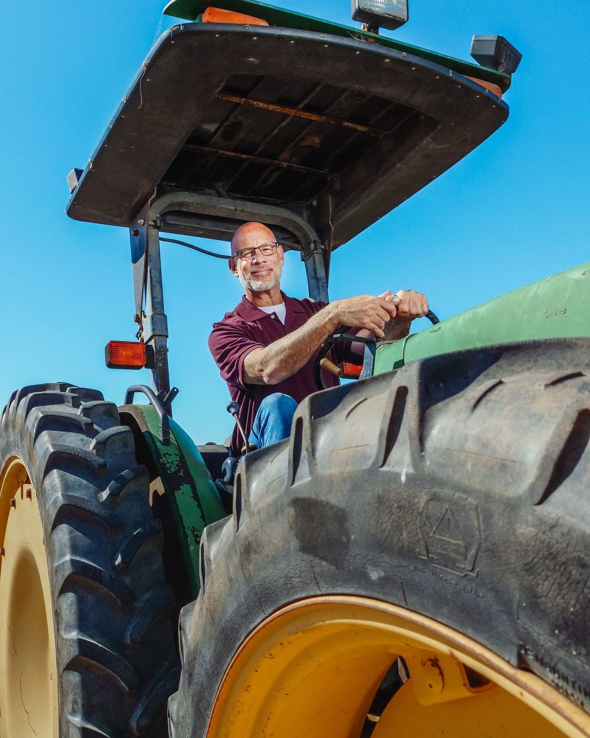 A grower at the wheel of a tractor